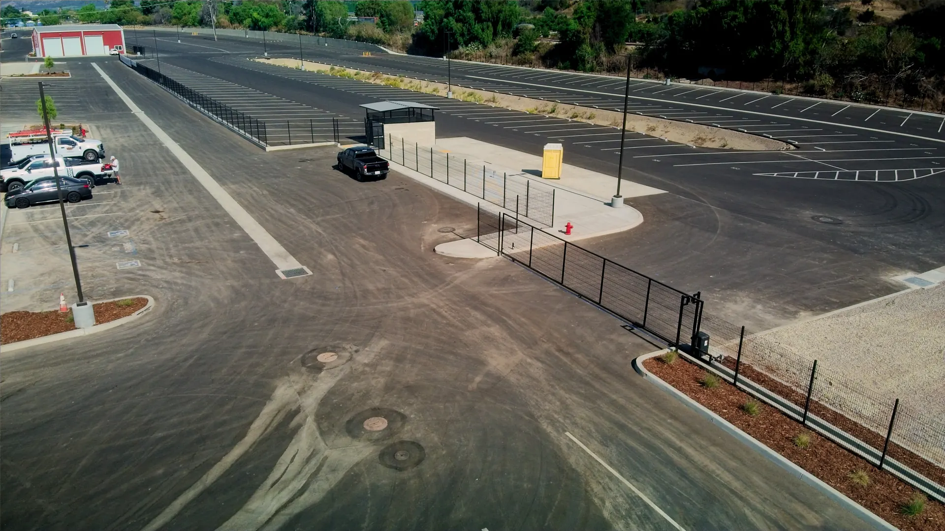 Aerial view of a commercial lot with new perimeter fencing and entry gate