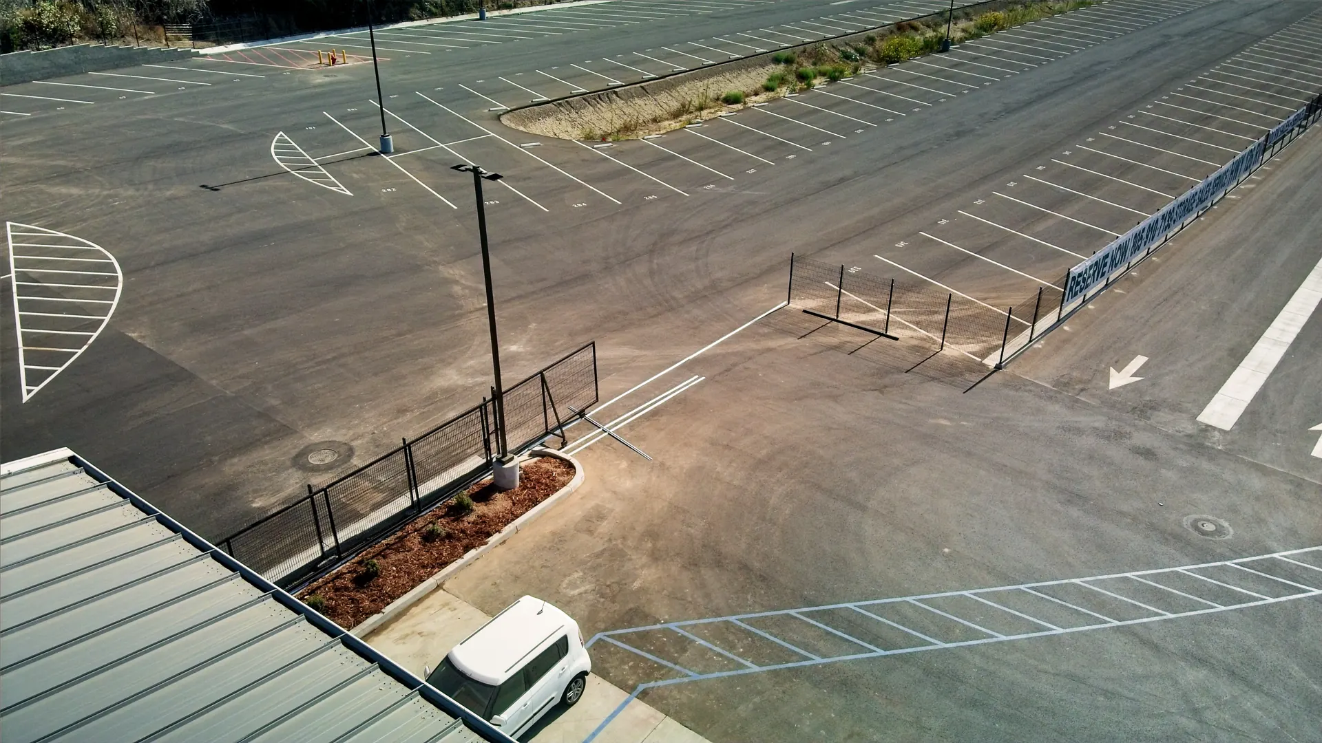 Steel fencing and gates dividing sections of a paved parking lot